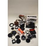 A box of camera filters, light meters, lenses and covertors