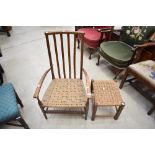 A traditional low arm chair having Beech wood frame with rush seat and matching foot stool