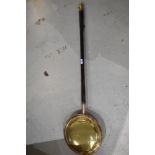 A traditional brass and copper bed warming pan