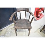 A 20th century smokers bow arm chair in dark stained Beech wood