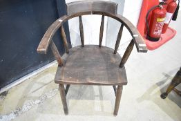 A 20th century smokers bow arm chair in dark stained Beech wood