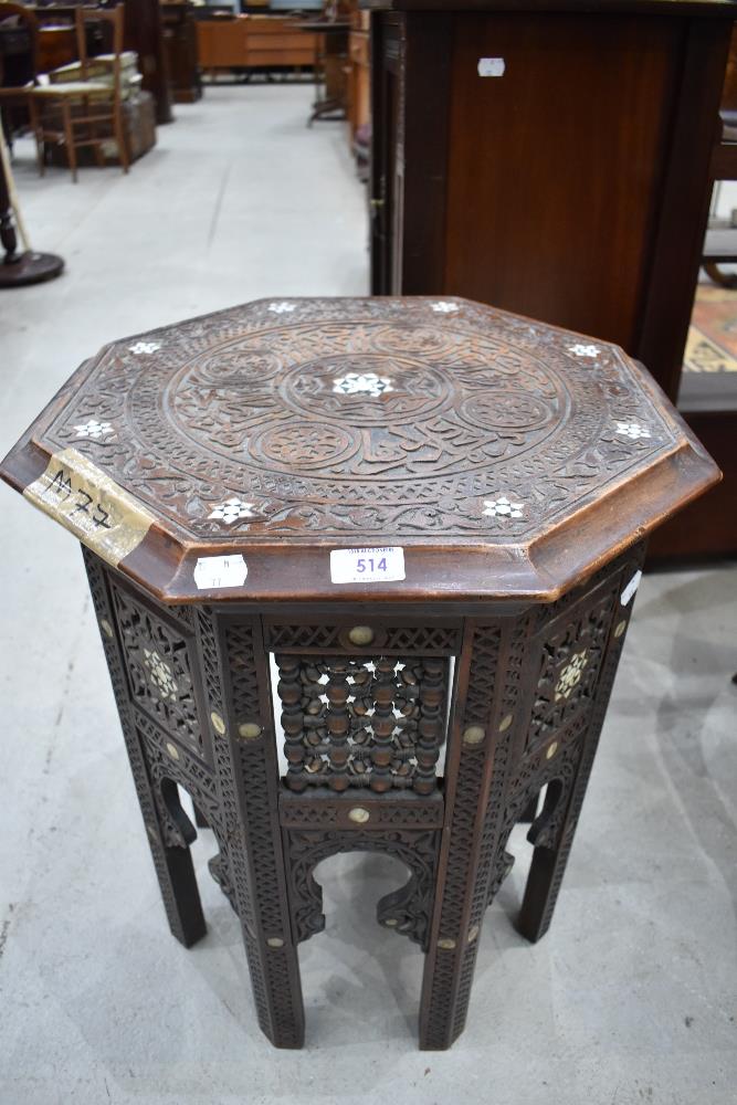 An Indian carved octagonal occasional table having mother of pearl inlay (af)