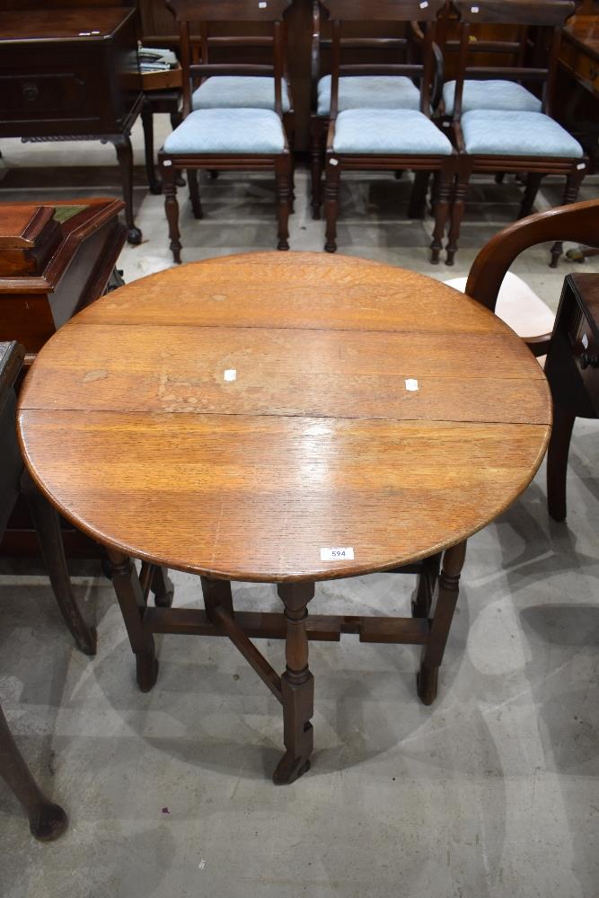 An early 20th century oak Sutherland table, of traditional design with turned gated supports and