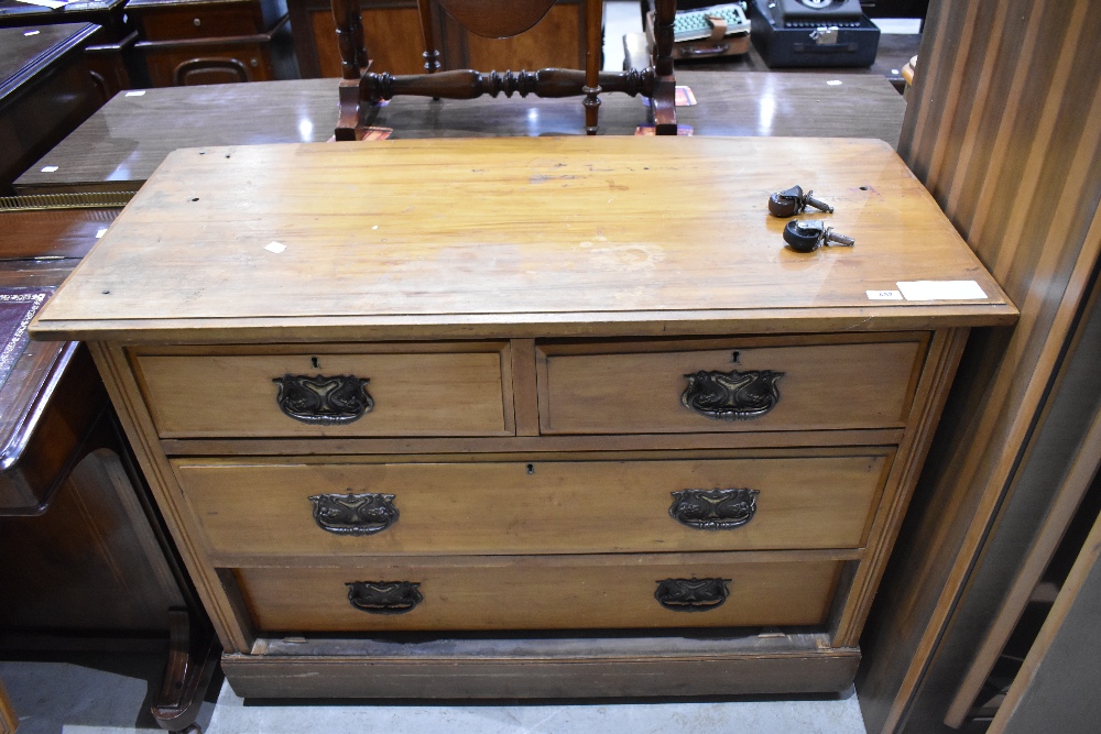 An Edwardian walnut chest of drawers, having two short and two long drawers, each with embossed