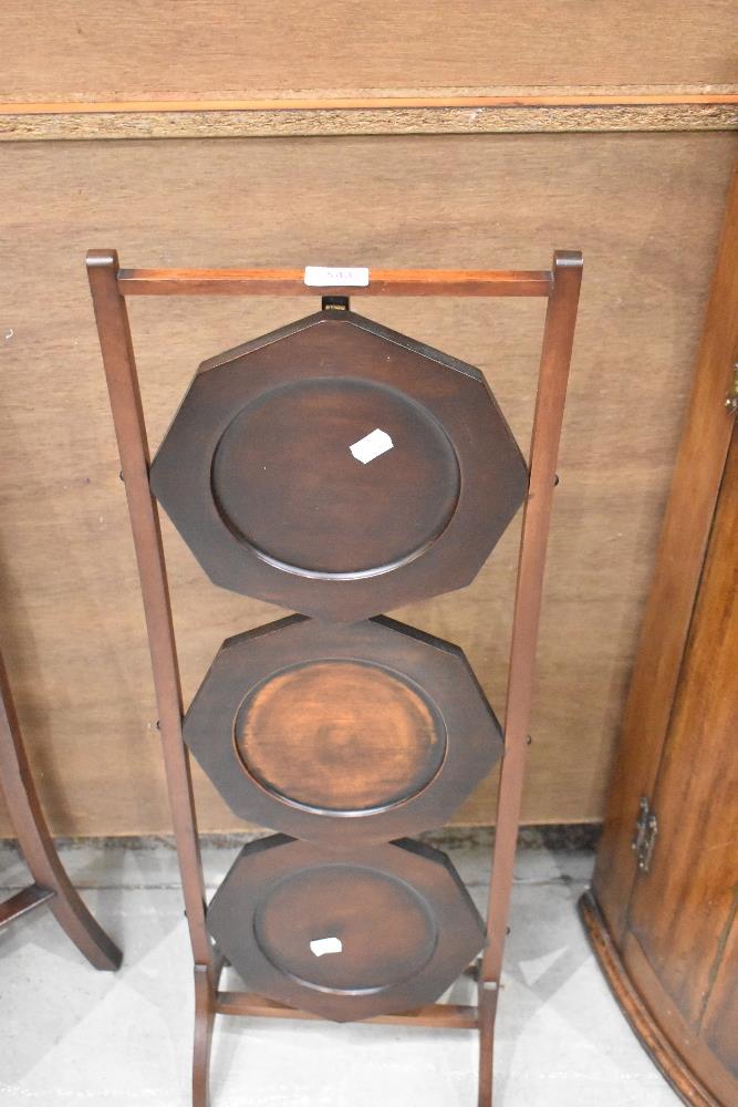 An early 20th Century mahogany folding cake stand , of triple octagonal tier form