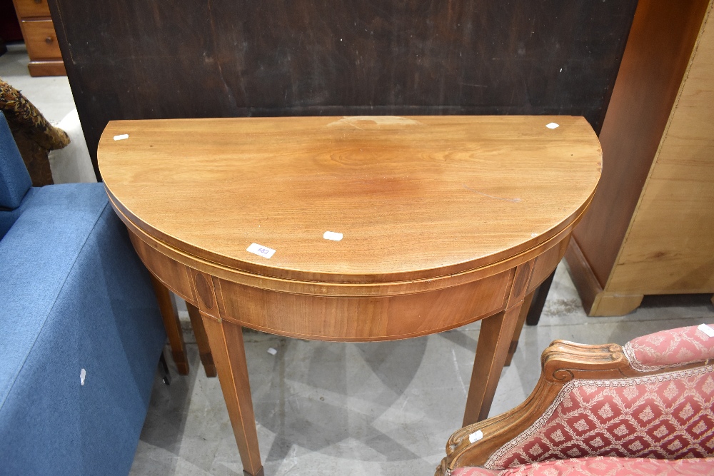 An Edwardian mahogany demi-lune fold-over tea table, of traditional design with boxwood stringing