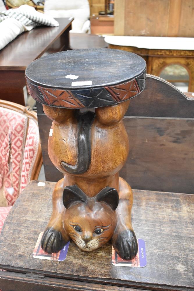 A modern carved and stained hardwood cat form occasional stand/table 49cm