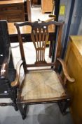A farm house style rocking chair having oak frame with woven fibre seat