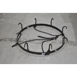 A vintage style kitchen pan rack in wrought iron with eight hooks