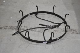 A vintage style kitchen pan rack in wrought iron with eight hooks