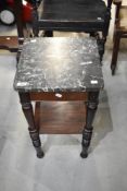 A Victorian pot stand with turned legs and black marble top.