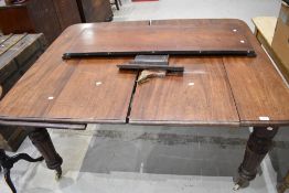 A Victorian extending dining table with mahogany frame and two additional leaf inserts.