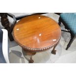 An early 20th Century mahogany circular coffee table having gadrooned edge and ball and claw feet