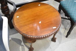 An early 20th Century mahogany circular coffee table having gadrooned edge and ball and claw feet