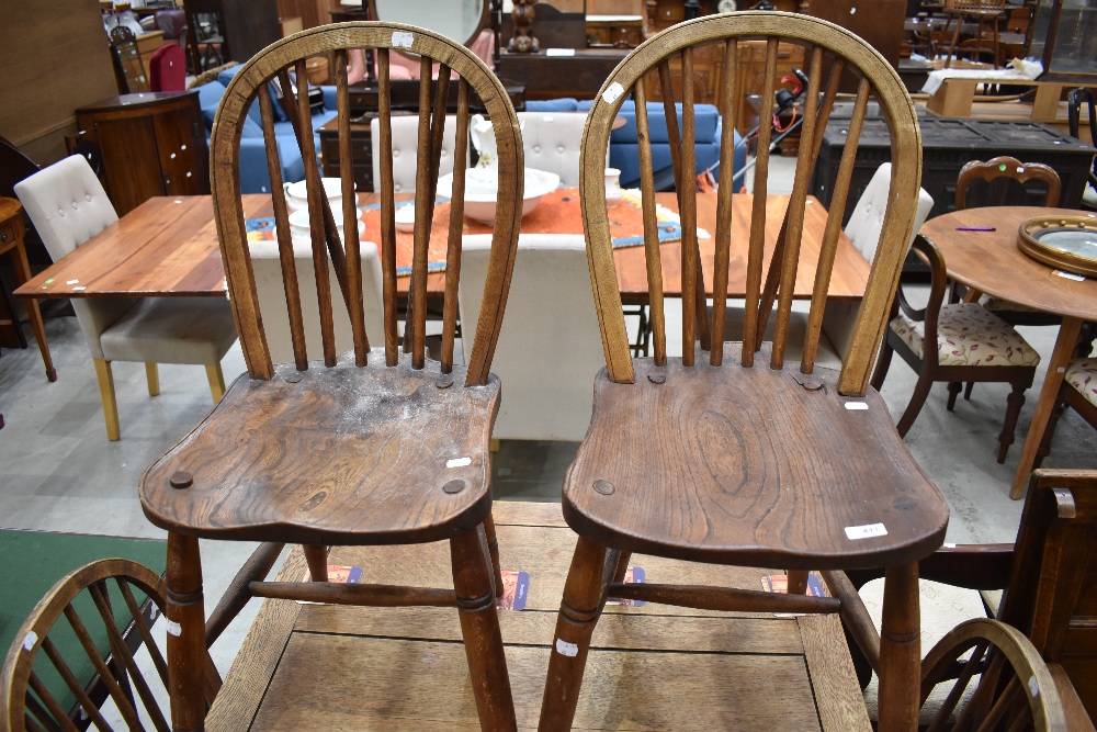 A set of four traditional spindle back kitchen chairs having turned frames with H stretcher, and elm