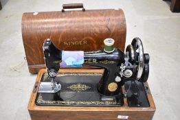 A vintage hand crank sewing machine , Singer number Y9437062, having oak ply dome case