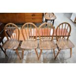 A set of four Ercol dining chairs with Elm seats and hoop backs.