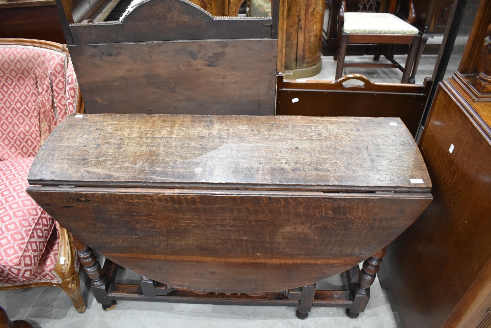 A 19th century oak drop-leaf gate legged table, having demi-lune flaps and turned supports, 75cm x