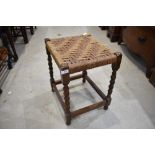 A traditional Beech framed stool with barley twist legs and woven seat top