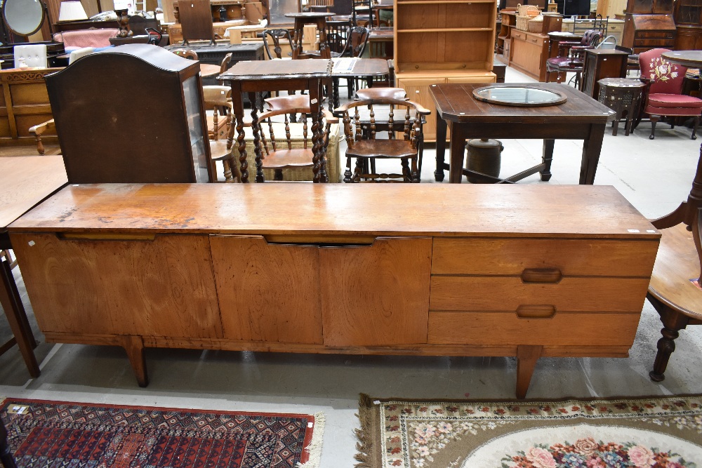 A mid century Teak long boy side board having three drawers and double cupboards in need of