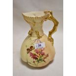 An early 20th century Royal Worcester blush ivory hand decorated ewer having a hand painted flower