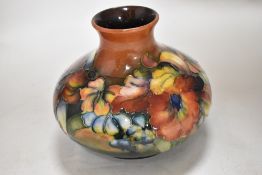 A mid 20th century Moorcroft pottery squat form vase tube lined in the Orchid pattern with a
