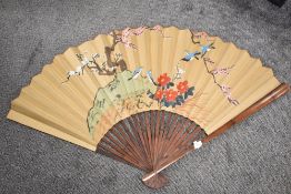 A large size Japanese fan being hand decorated with fantasy landscape.