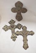 Three modern resin cast wall mounted crucifix decorations.