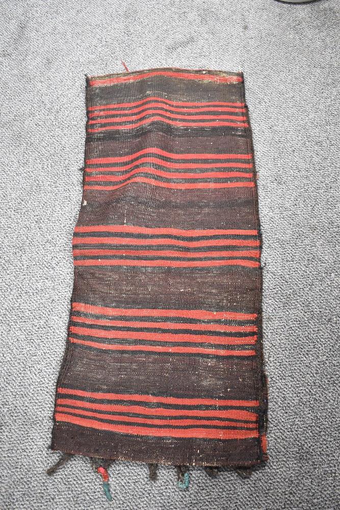 A 20th century Persian Afghan Balouch saddle bag in woven wool in a black and red ground 110cm x - Image 2 of 2