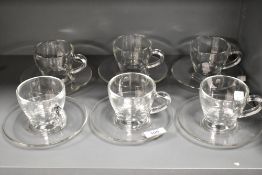 A set of six modern designer glass cups and saucers made in Italy.