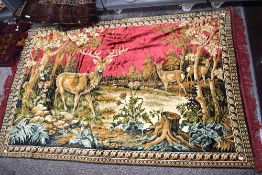 A mid century tapestry style wall hanging or rug with deer and stag imagery.