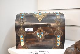 A mid Victorian dome topped chest tea caddy having brass banding and azure blue cabochon decoration.