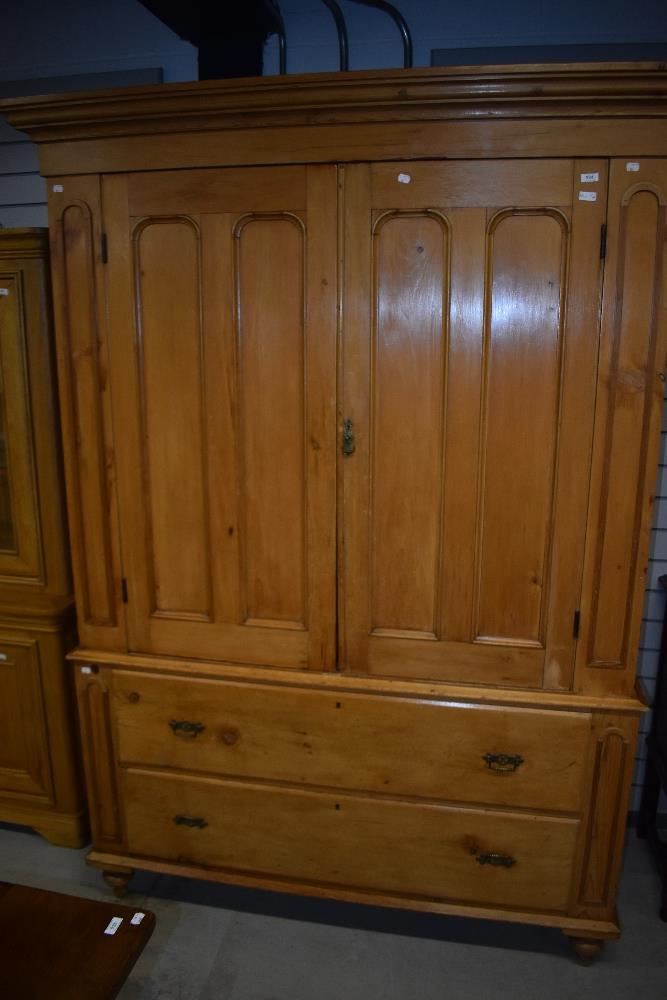 A Victorian stripped pine press cupboard having two drawers to base with brass Aesthetic style