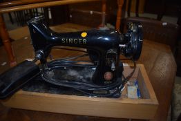 A vintage Singer 99K electric sewing machine having wooden base (no lid)