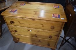 A yellow pine bedroom chest of three long drawers
