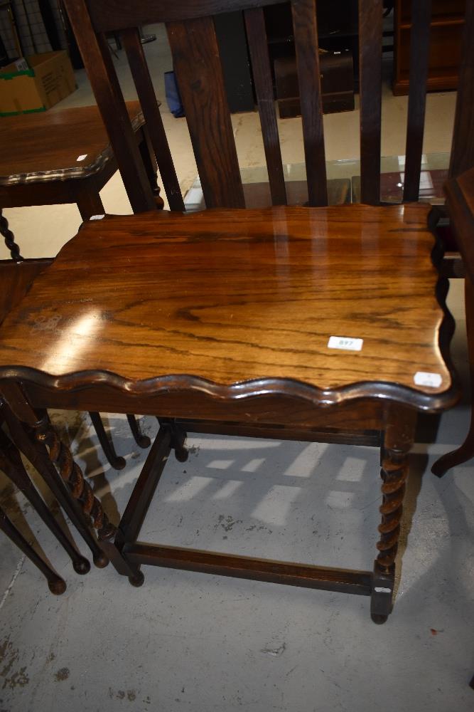 An early 20th Century oak occasional table having shaped top on twist leg frame