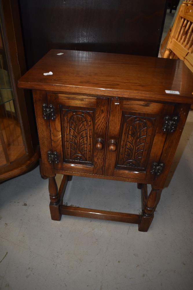 A late 20th Century reproduction oak side cabinet of small form, in the Old Charm style