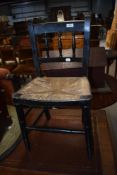 A 19th Century stained frame childs chair having spindle back and rush seat