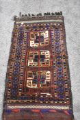 A vintage saddlebag rug, having traditional pattern in red, blue, green, brown and cream.