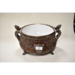 A large Victorian design carved oak punch bowl having ceramic liner and cast metal feet and