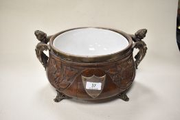 A large Victorian design carved oak punch bowl having ceramic liner and cast metal feet and