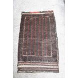 A vintage saddlebag rug, having traditional pattern, In darker tones.