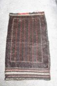 A vintage saddlebag rug, having traditional pattern, In darker tones.