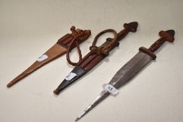 Two ethnic knives having leather sheaths.