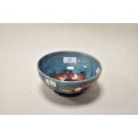 A Mid century Moorcroft pottery bowl having teal blue ground with tube lined Anemone design in