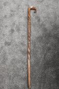 An antique carved walking stick having twist stem with carved belt like bands and horse's foot