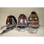 Three vintage Thai mountain tribe hats, having coin, bead and shell decoration.