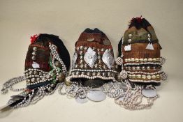 Three vintage Thai mountain tribe hats, having coin, bead and shell decoration.