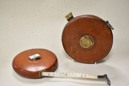 Two vintage leather bound tape measures, marked Rabone Chesterman Ltd with brass winders.