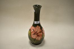 A 1982 dated Moorcroft pottery vase of elongated baluster form, having green ground with tube